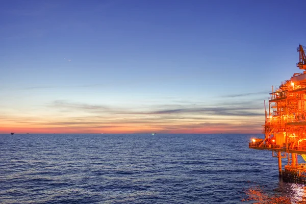 Sol posto no mar a partir de plataforma offshore com luz quente e li — Fotografia de Stock