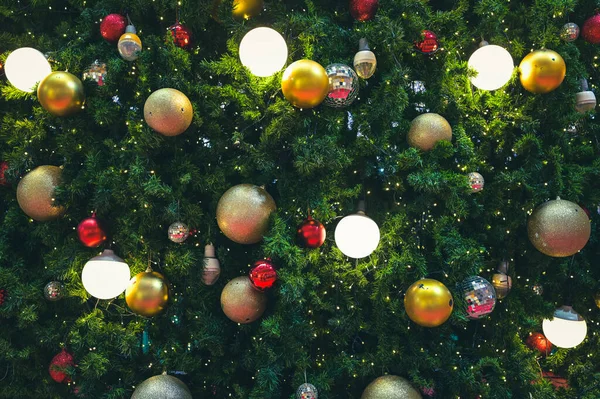 Süslü Noel ağacı ve yeni yıl tatili ışıldıyor, parlıyor. Mutlu yıllar teması Bokeh arka planını bulanıklaştırdı.