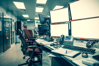Kontrol fabrikası süreci veya borsa ticareti için kontrol odasındaki boş monitörlerin yan görünümü.