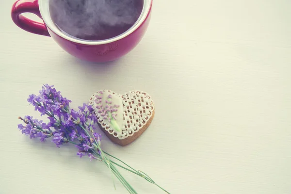çay bardağı ile tatlı kalp şeklinde çerez ve tonda lavandula,