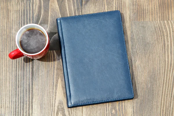 Чашка кофе и блокнот — стоковое фото