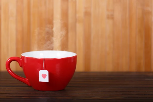 Taza de té con forma de corazón en mesa de madera — Foto de Stock