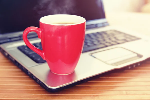 Чашка кофе на ноутбуке — стоковое фото