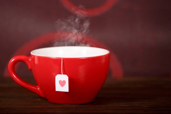 Taza de té con forma de corazón en mesa de madera — Foto de Stock