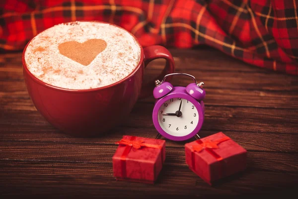 Taza de café, pequeño despertador púrpura y mini cajas de regalo — Foto de Stock