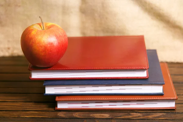 Notebooki i apple na drewnianym stole nad tło grunge — Zdjęcie stockowe