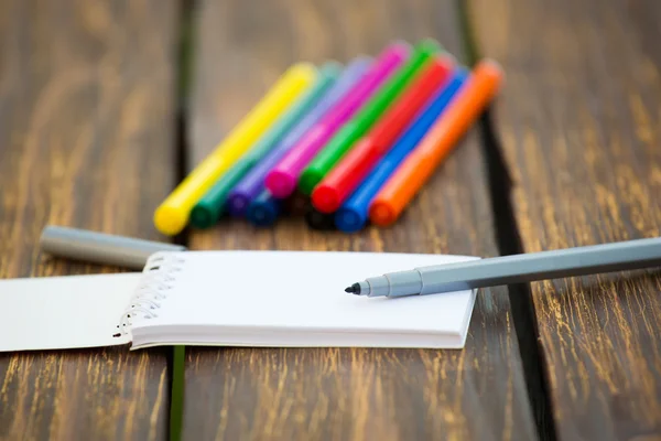 Фетровая ручка и блокнот на деревянном фоне — стоковое фото