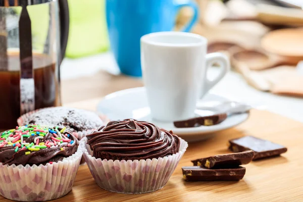 Cup of coffee and a cup cake on a wooden surface — Stock Photo, Image