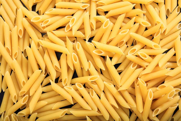 Full background of raw penne pasta — Stock Photo, Image