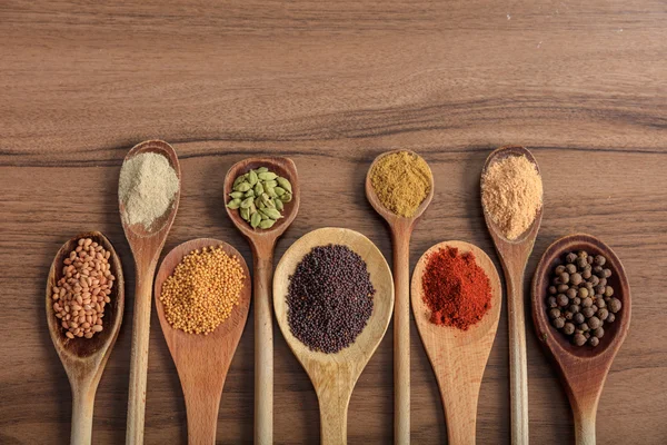 Mängd olika kryddor på en trä yta — Stockfoto