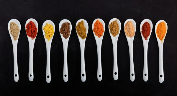 Various spices in porcelain spoons — Stock Photo, Image