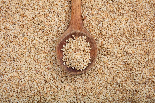 Cuchara de madera sobre fondo de sésamo blanco — Foto de Stock