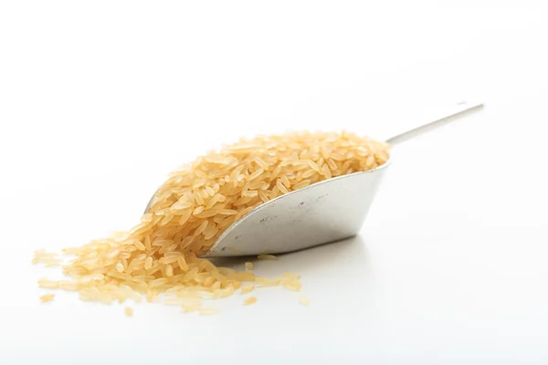 Arroz crudo cocido en una cucharada metálica — Foto de Stock