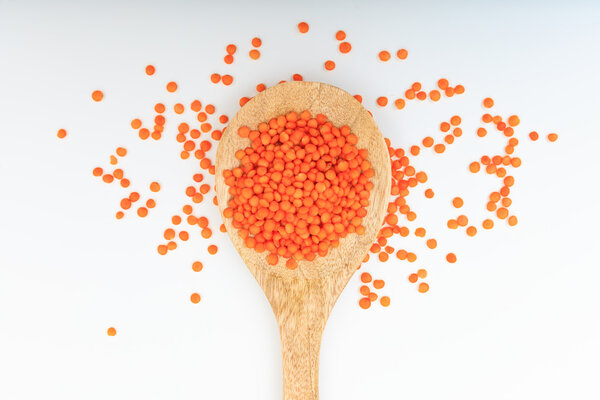 Сырая оранжевая чечевица в деревянной ложке
 