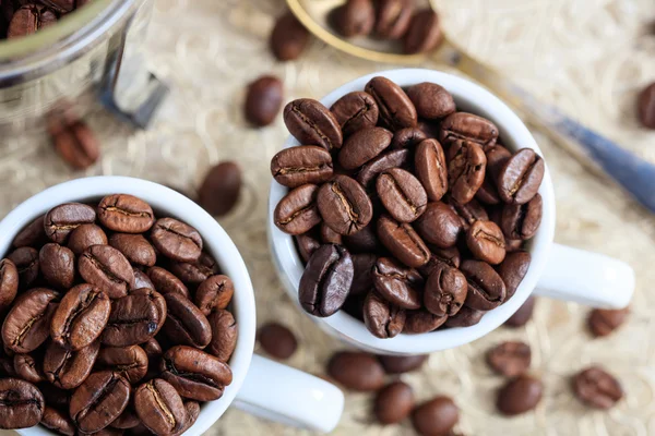 Cups with coffee beans — Stock Photo, Image