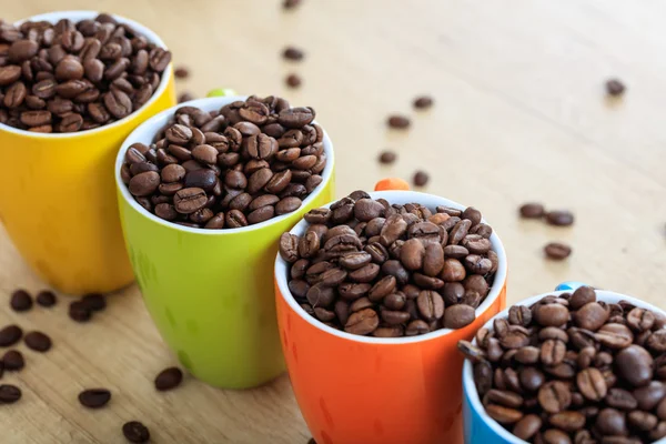 Чашки полные кофейных зерен — стоковое фото
