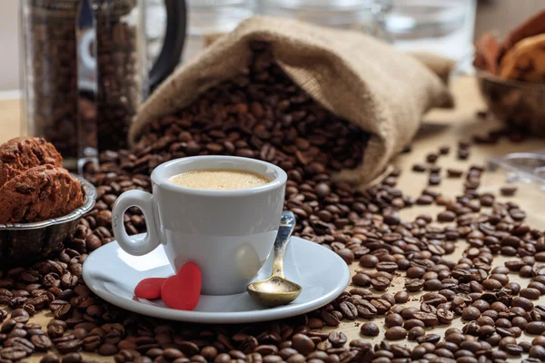 Кофейные зерна из мешка и чашка кофе — стоковое фото