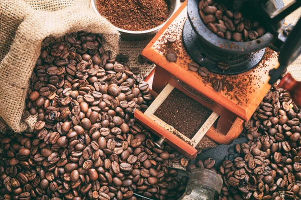 Grains de café et un moulin à café — Photo