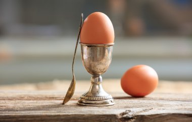 Eggs and egg cup in an old tray clipart