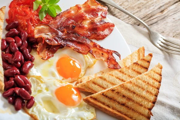 Fried eggs, bacon and red kidney beans — Stock Photo, Image
