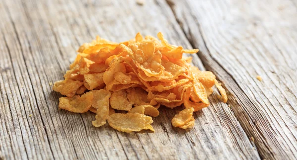 Corn flakes heap on a wooden table — Stock Photo, Image