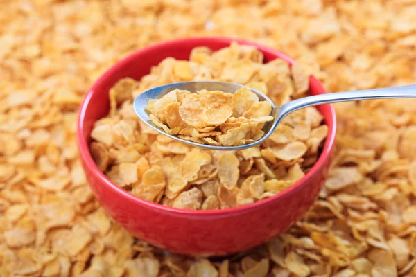 Bowl with corn flakes on corn flakes background