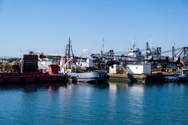 Drapetsona Pire 'nin eski limanında demirlemiş sanayi gemileri ve tekneleri. Yunanistan, mavi gökyüzü ve deniz, güneşli bir gün..