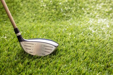 Yeşil sahada golf sopası, güneş ışığı yansımaları, yakın görüş. Golf sporu ve kulüp konsepti. Uzayı kopyala, şablon