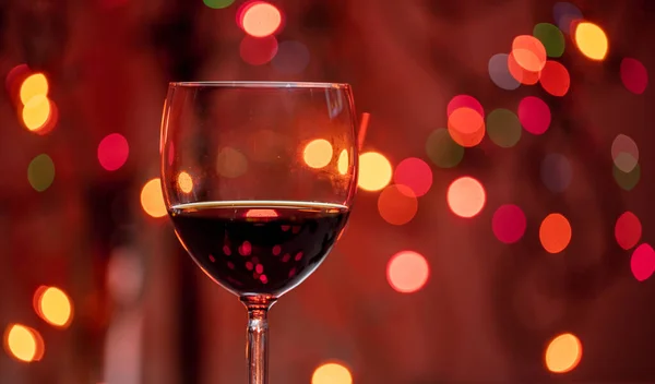 Κόκκινο Ποτήρι Κρασί Κατά Χριστουγεννιάτικα Φώτα Πολύχρωμο Φόντο Bokeh Closeup — Φωτογραφία Αρχείου