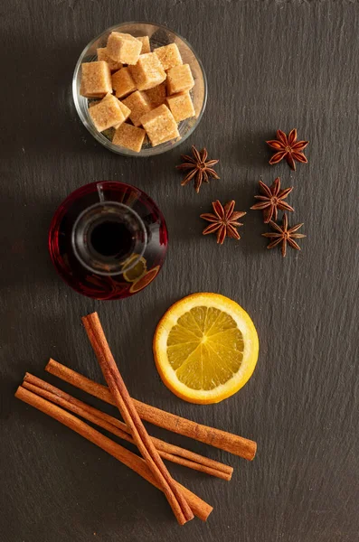 複数のワインのレシピ成分 クリスマスの冬の暖かいアルコール飲料 オレンジ シナモンスティック 黒石の星のアニスと砂糖 トップビュー — ストック写真