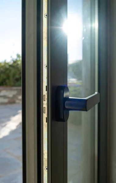 Aluminum door detail. Metal window frame open closeup view. Energy efficient, safety profile, blur outdoor background