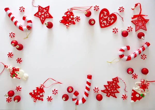 白い背景に対するクリスマスオーナメントの泡と甘いキャンディーの赤い色 クリスマスフレームフラットレイ ホリデーグリーティングカードテンプレート トップビュー — ストック写真