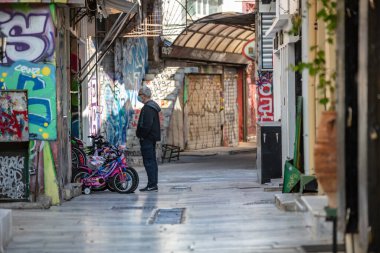 Atina, Yunanistan - 10 Kasım 2020. COVID19 koronavirüs kilitlenmesi. Şehir merkezinde koruyucu maskeli bir adam duruyor, sokaklar boş, iş yeri kapalı, Monastiraki turistik bölgesi