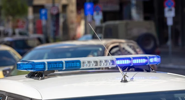 蓝色灯罩在警车顶部的特写镜头下 模糊了城市景观背景 屋顶安装了光棍和警笛 应急车辆 市政警察 — 图库照片