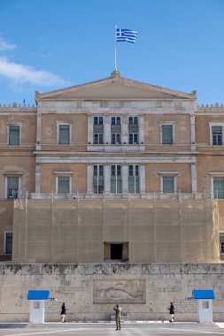 Atina Yunanistan, 19 Kasım 2020. Yunan Parlamentosu binasının önündeki bilinmeyen asker mezarında mavi gökyüzü arka planında cumhurbaşkanı muhafızları devriye geziyor.