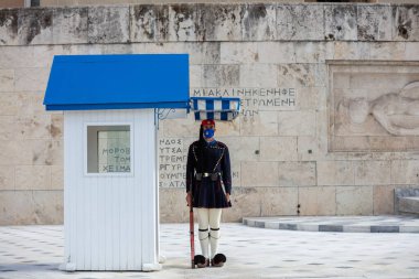 Atina Yunanistan, 19 Kasım 2020. Yunan Parlamentosu binasının önünde duran COVID 19 koruyucu yüz maskesi takan başkanlık muhafız birliği. Coronavirus günlerinde turistik ilgi.