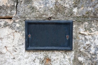 Sokak numarası boş metal plaka taş duvara monte edilmiş. Geleneksel ev adresi şablonu, kopyalama alanı