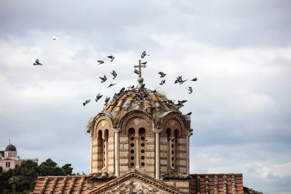 ギリシャのアテネのティシオ地区にあるギリシャ正教会のドームの周りを飛ぶハトの群れ 国立天文台と曇天の背景 — ストック写真