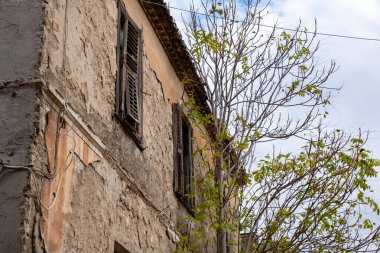 Terk edilmiş bir binanın dış cephesi, bulutlu bir arka plan, Plaka, Atina Yunanistan. Düşük açı görünümü