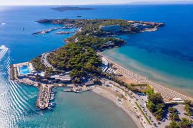Atina Riviera, güney kıyısı, Yunanistan. Asteras Vouliagmeni lüks otel hava aracı manzaralı. Şeffaf turkuaz deniz suyu ve kumlu sahil, güneşli yaz günü..