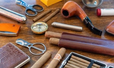 Sigara seti aksesuarları. Puro, pipo, sigara ve sigara, makaslar, çakmaklar, ahşap bir masa arkasında kutular. Küba kalite purolar, lüks yaşam tarzı yakın çekim manzarası