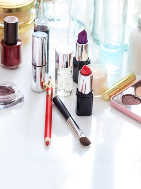 Makyaj malzemeleri beyaz arka planda. Kozmetik endüstrisi cilt bakımı, moda, güzellik ve kadın yüzü ve tırnaklarının korunması için lüks bir koleksiyon yaratıyor. Dikey, yakın görünüm.