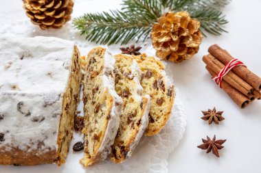 Christstollen beyaz arka planda dilimler. Noel pastası tatlı Alman geleneksel ekmeği mevsimlik tatlı kuru üzüm, fındık, baharat, kurutulmuş meyve ve kremalı şeker.
