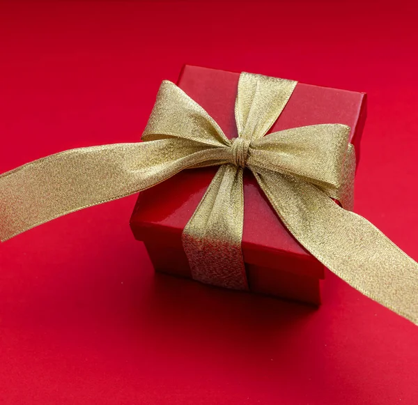 Pudełko Złotą Wstążką Czerwonym Tle Błyszczący Pakiet Walentynki Prezent Boże — Zdjęcie stockowe