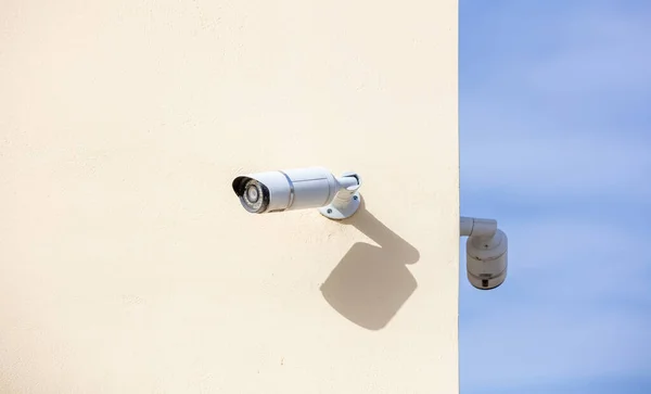 CCTV Cameras, Security system. Surveillance cams on painted wall, bkue sky background, copy space