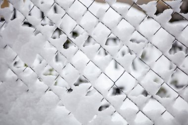 Karla kaplı tel örgü, kış mevsimsel soyut arka plan dokusu. Beyaz kış ayazında metal çitler. Güvenlik, gizlilik kavramı