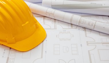 İnşaat konsepti. Proje planları ve çizimlerin arka planında sarı başlık, kopyalama alanı. İnşaat alanı ofisi, işgücü güvenliği