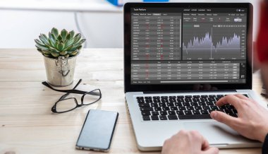 Trade platform, forex trading. Stock exchange market analysis, Man working with a laptop, monitoring app on screen, office desk background. Binary option, candlestick chart.