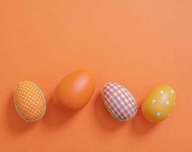 Happy Easter greeting card template. Easter eggs collection on pastel orange color background, top view. Christian religion holiday celebration and decoration.
