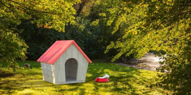 Parkta köpek kulübesi ve köpek maması. Kırmızı çatılı ahşap evcil hayvan evi ve tabakta bir kemik, yeşil doğa ağaçları ve çimen arka planı, güneşli bir gün, 3D illüstrasyon